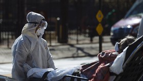 A medical worker pushes a stretcher outside the Elmhurst Hospital Center in the Queens borough of New York, on March 26. Photographer: Angus Mordant/Bloomberg