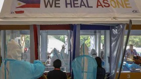 Nhân viên y tế xét nghiệm cho nhân viên chính phủ ở TP Quezon, Đông Bắc Manila hôm 30-7. Ảnh: EPA