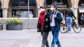Người dân đeo khẩu trang phòng dịch COVID-19 khi di chuyển trên phố ở Munich, Đức. Ảnh: THX/TTXVN