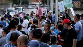Cư dân và những người ở gần khu chợ đầu mối Tân Phát Địa tại thủ đô Bắc Kinh, Trung Quốc xếp hàng chờ xét nghiệm COVID-19 - Ảnh: AFP