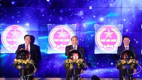 Thủ tướng Nguyễn Xuân Phúc thực hiện nghi thức hòa mạng các chi cục thuế khu vực vào hệ thống quản lý thuế chung cả nước. Ảnh: TTXVN