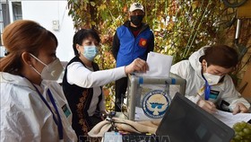 Cử tri bỏ phiếu tại một địa điểm bầu cử ở Bishkek, Kyrgyzstan. Ảnh: AFP/TTXVN
