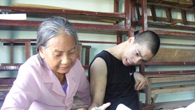 Bà giáo Nguyễn Thị Thông đang dạy cho cháu Nguyễn Văn Nguyên