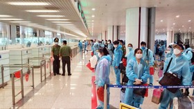 Hành khách chuyến bay thương mại quốc tế đầu tiên về Việt Nam đang làm thủ tục nhập cảnh