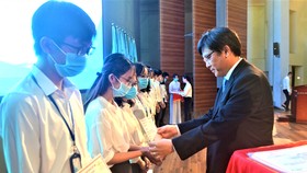 PGS-TS Nguyễn Minh Tâm, Phó Giám đốc ĐH Quốc gia TPHCM, trao học bổng cho sinh viên có hoàn cảnh khó khăn, học giỏi