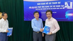 Ông Lê Quốc Cường, Phó Giám đốc Sở TT-TT TPHCM (giữa) trao bài dự thi hội thi cho đại diện ban giám khảo