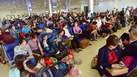 Hành khách vạ vật tại sân bay Tân Sơn Nhất, TP.HCM chờ đến giờ bay vào dịp tết - ẢNH: QUANG ĐỊNH