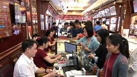 Khách hàng đang giao dịch vàng miếng. (Ảnh: Đức Duy/Vietnam+)