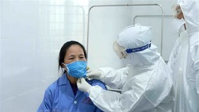 Bác sỹ Đội cơ động Bệnh viện Bạch Mai (Hà Nội) thăm khám cho bệnh nhân tại Trung tâm y tế huyện Bình Xuyên, Vĩnh Phúc. (Ảnh: Hoàng Hùng/TTXVN)