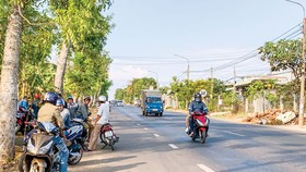 Cò đất tập trung hai bên Quốc lộ 56 chèo kéo khách đi đường. Ảnh: MINH TUẤN