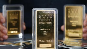 Nhân viên giới thiệu các thanh vàng tại cửa hàng ở Seoul, Hàn Quốc. (Ảnh: YONHAP/TTXVN)