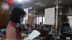 Người dân nhận giấy đăng ký kinh doanh. (Ảnh Mạnh Khánh/TTXVN)