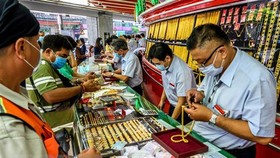 Người dân mua bán vàng tại một cửa hàng ở Bangkok, Thái Lan. (Ảnh: AFP/TTXVN)
