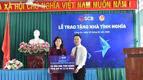 Ông Đinh Văn Thành – Chủ tịch HĐQT SCB trao bảng tượng trưng trao 20 căn nhà tình nghĩa tại Long An.