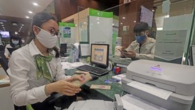 Khách hàng giao dịch tại hội sở chính Vietcombank, 198 Trần Quang Khải, Hà Nội. (Ảnh: Trần Việt/TTXVN)