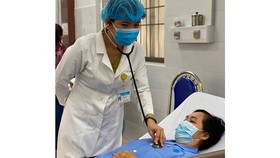 Bác sĩ chăm sóc cho bệnh nhân sau khi điều trị thành công