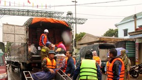 Đưa hàng hóa cứu trợ đến với người dân vùng lũ. (Ảnh: Văn Tý/TTXVN)