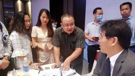 Đại diện doanh nghiệp lên bàn chủ tọa chất vấn ông Đặng Ngọc Minh (phó tổng cục trưởng Tổng cục Thuế) trong giờ giải lao - Ảnh: N.PHƯỢNG