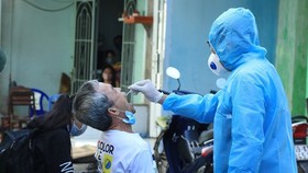 Nhân viên y tế lấy mẫu xét nghiệm người dân trong khu vực Lô E, Lò Gốm (Phường 7, Quận 6). (Ảnh: Đinh Hằng/TTXVN)