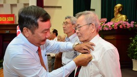 Bí thư Quận ủy quận 2 Trần Văn Thuận (trái) trao Huy hiệu Đảng cho các đảng viên cao tuổi Đảng trên địa bàn quận. Ảnh: KIỀU PHONG