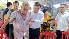 Chủ tịch UBND TPHCM ân cần thăm hỏi sức khỏe ông Huỳnh Quang Hải và gia đình ông. Ảnh: KIỀU PHONG