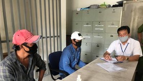 Lực lượng tiến hành xử phạt 2 thanh niên không đeo khẩu trang nơi công cộng. Ảnh: C.T