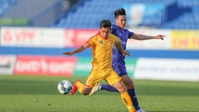 Cuộc đối đầu giữa kinh nghiệm của Đình Tùng và sức trẻ của Tấn Tài trên sân Bình Dương. Ảnh: Dũng Phương