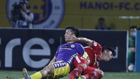 Văn Quyết tranh bóng cùng Tiến Dũng. Ảnh: MINH HOÀNG