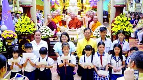Tổng Lãnh sự Thái Lan tại TPHCM Apirat Sugondhabhirom (áo vàng) trao học bổng cho học sinh nghèo tại chùa Phổ Minh (TPHCM)
