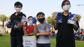 Nhóm học sinh phát khẩu trang vải miễn phí cho người đi đường