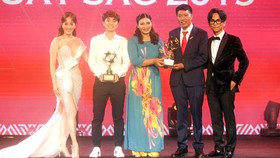 Cha và mẹ cùng lên sân khấu nhận giải Cầu thủ nam trẻ xuất sắc thay cậu con trai Đoàn Văn Hậu. Ảnh: DŨNG PHƯƠNG