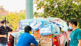 Thành viên Câu lạc bộ Xe bán tải Đà Nẵng đưa hàng hóa, nhu yếu phẩm, đồ bảo hộ chống dịch đến các khu cách ly. Ảnh: NGUYỄN CƯỜNG