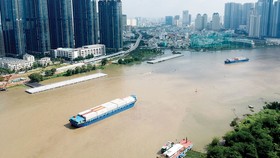 Sà lan vận chuyển hàng hóa trên sông Sài Gòn qua khu vực trung tâm TPHCM. Ảnh: CAO THĂNG