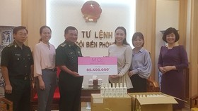 Đại diện Công ty Mỹ phẩm thương hiệu Việt M.O.I Cosmetics trao bảng tượng trưng số tiền tặng Bộ đội biên phòng