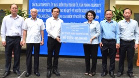 Đồng chí Trần Lưu Quang trao ủng hộ Quỹ Vì người nghèo TPHCM. Ảnh: VIỆT DŨNG