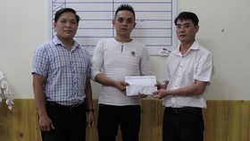 Đại diện Báo SGGP tại miền Trung và chính quyền địa phương trao tiền hỗ trợ cho gia đình cháu Huy