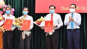 Phó Bí thư Thường trực Thành ủy Trần Lưu Quang trao quyết định cho 3 đồng chí Lê Văn Tân, Nguyễn Thọ Truyền, Đặng Nguyễn Thanh Minh. Ảnh: VIỆT DŨNG