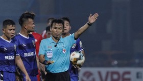 Trọng tài Trương Hồng Vũ bị cầu thủ Bình Dương phản ứng trong trận gặp Viettel. Ảnh: MINH HOÀNG