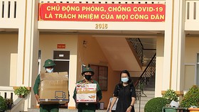 Các chiến sĩ Sư đoàn 317 giúp công dân đưa hành lý ra xe. Ảnh: HOÀNG HÙNG