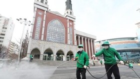Công nhân khử trùng một khu vực xung quanh nhà thờ Myungsung, một nhà thờ có 80.000 tín đồ, tại Seoul, ngày 26-2, sau khi một mục sư của nhà thờ xét nghiệm dương tính với chủng mới của virus Corona. Ảnh: Yonhap