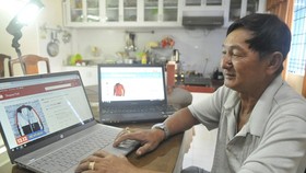 A customer does online shopping. (Photo: SGGP)