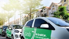 Cars which provide passenger transportation via ride-hailing platforms like Grab will have to put on top TAXI sign or carry logo stickers showing that they are contract vehicles. (Photo: VNA)