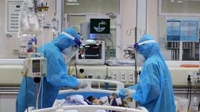 Medical workers tend to a COVID-19 patient (Photo: VNA)