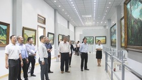 Vice Chairman of the municipal People’s Committee, Duong Anh Duc leads a delegation of officials to visit Mr. Bui Van Ngo's exhibition room. (Photo: SGGP)
