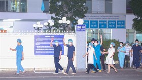 Doctors and nurses walk through entrance of the C Hospital in Da Nang after lockdown was lifted (Photo: VNA)