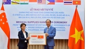 Singaporean Ambassador Catherine Wong Siow Ping (left) receives a donation of Reverse Transcription Polymerase Chain Reaction test kits from Vietnamese Deputy Foreign Minister Nguyen Quoc Dung in May.
