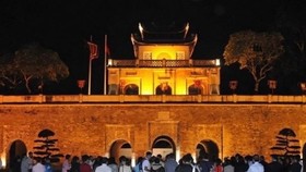 Visitors stand in front of Doan Mon (Main Gate) of the Thang Long Imperial Citadel in the evening (Photo: VNA)