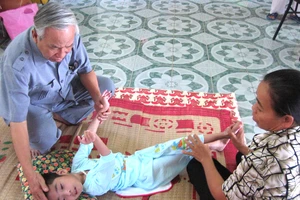 Ông Lê Văn Hoan thăm một cháu bé được phục hồi chức năng