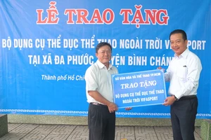 Ông Võ Trọng Nam (phải, Phó Giám đốc Sở VH-TT TPHCM) trao bảng tặng tượng trưng cho ông Phạm Thanh Hùng, Phó chủ tịch UBND xã Đa Phước.
