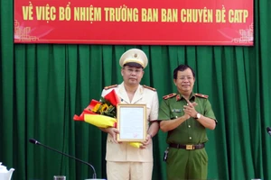 Thiếu tướng Trần Đức Tài, Phó Giám đốc Công an TPHCM trao quyết định, tặng hoa chúc mừng Đại tá Bùi Ngọc Giáp